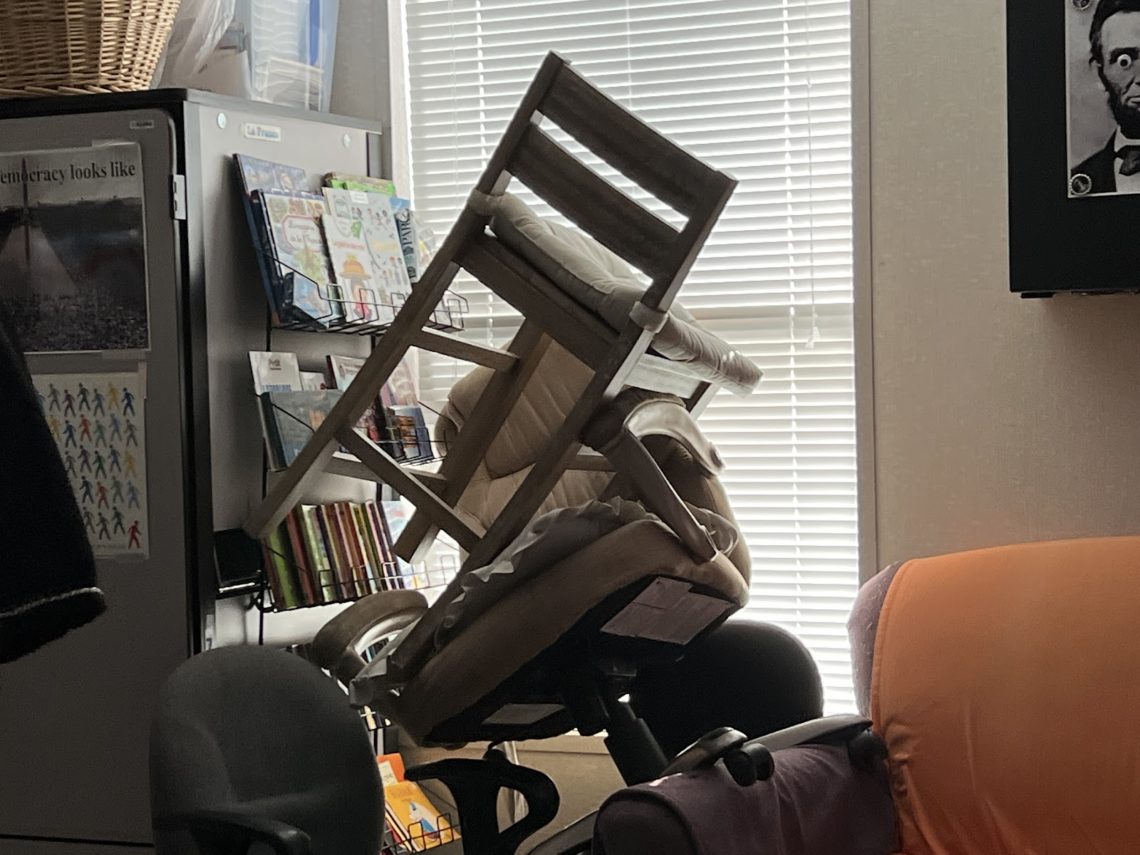 In a classroom, chairs are stacked upon each other to form a barricade in front of a window with drawn blinds during a summer ALICE (Alert, Lockdown, Inform, Counter, Evacuate) drill.