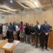 The school board with student representatives and Superintendent Kay-Wyatt gather around the dais and Kay-Wyatt poses with flowers.