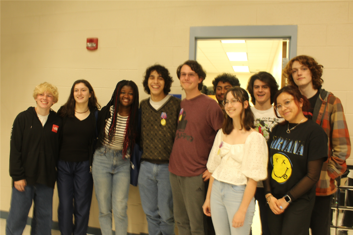 Award recipients and student crew pose for a photo in the TV studio. From left: sophomore Leo Dienstfrey, sophomore Marisa Vidal, junior Lashelle Sakyi, junior Gryphon Magnus, junior Ben Delnegro, junior Lester “Rocky” Hernandez, junior Sarah McBurney, senior Max Rocchio, senior Alison Avelar and junior Aidan Hill